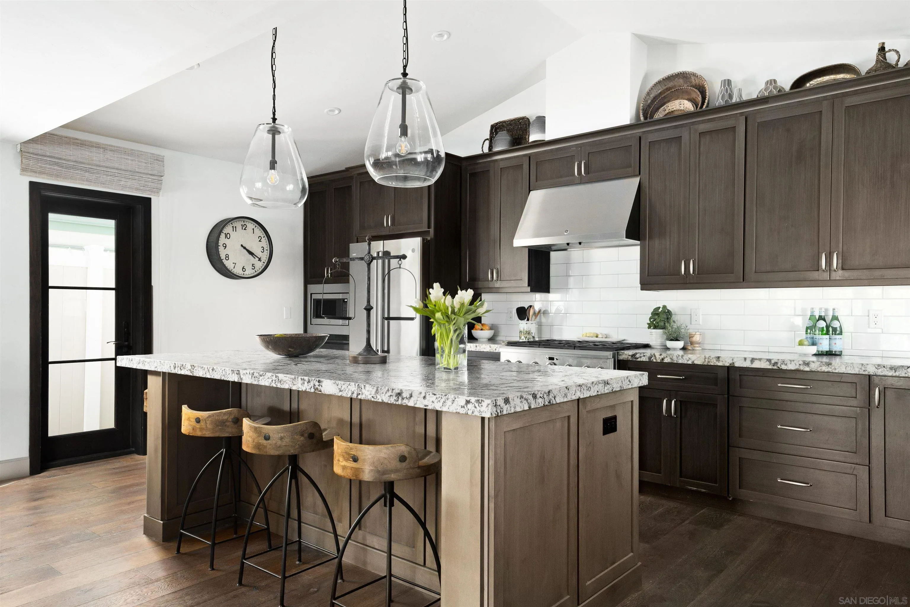 5351 Saxon Street San Diego, CA 92115 - Photo 5 of 34 a kitchen with granite countertop a table chairs stove and cabinets