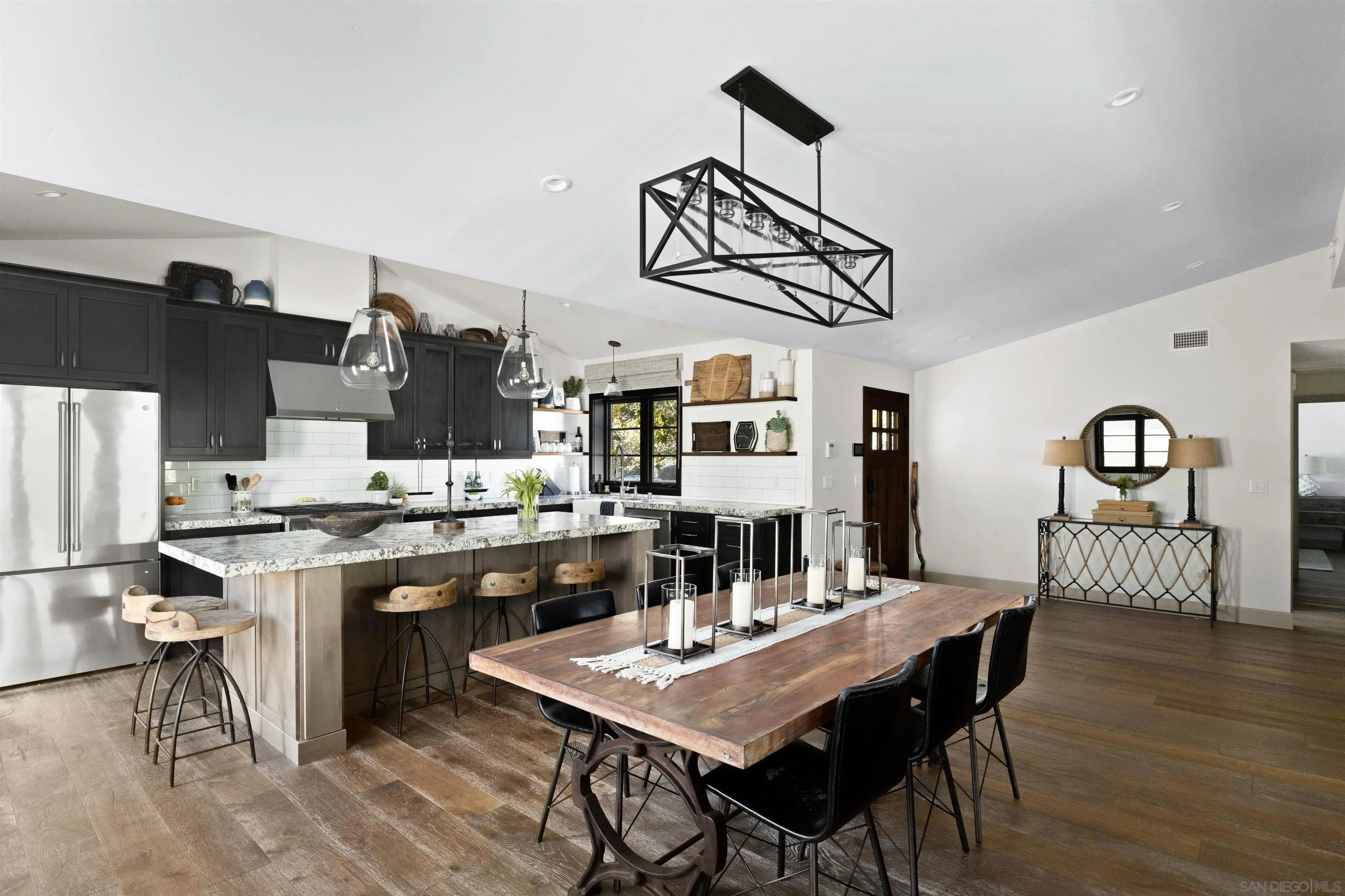 5351 Saxon Street San Diego, CA 92115 - Photo 7 of 34 a open kitchen with stainless steel appliances granite countertop a stove top oven a sink a dining table and chairs with wooden floor