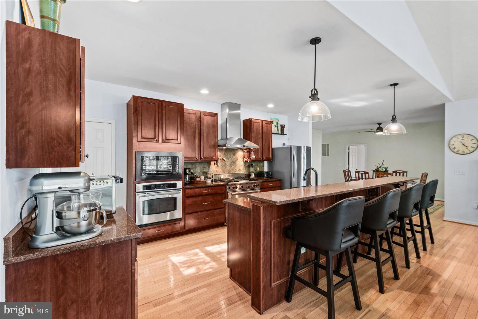8 Franklin Cove Ruther Glen, VA 22546 - Photo 12 of 70 a kitchen with stainless steel appliances kitchen island granite countertop a sink a stove and chairs