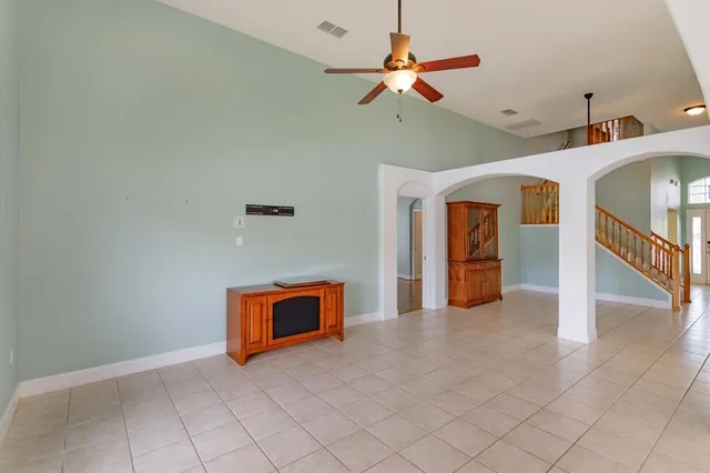 a view of a livingroom with a ceiling fan and staircase