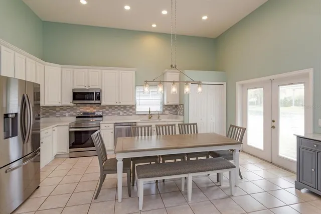 a kitchen with granite countertop a stove a sink and a refrigerator
