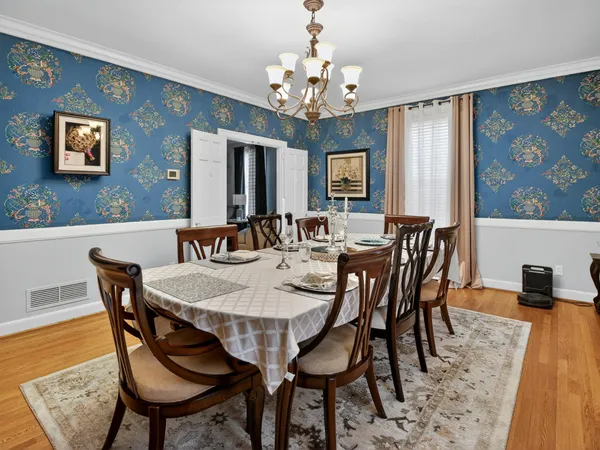a kitchen with a stove a sink dishwasher and a dining table with wooden floor