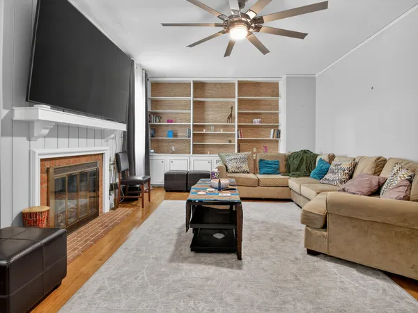 a living room with furniture a flat screen tv and a fireplace