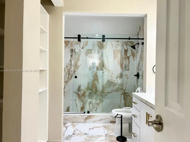 a bathroom with a granite countertop sink a toilet and a mirror