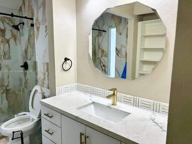 a bathroom with a sink toilet and shower