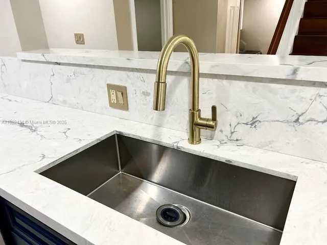 a kitchen with stainless steel appliances and view of living room