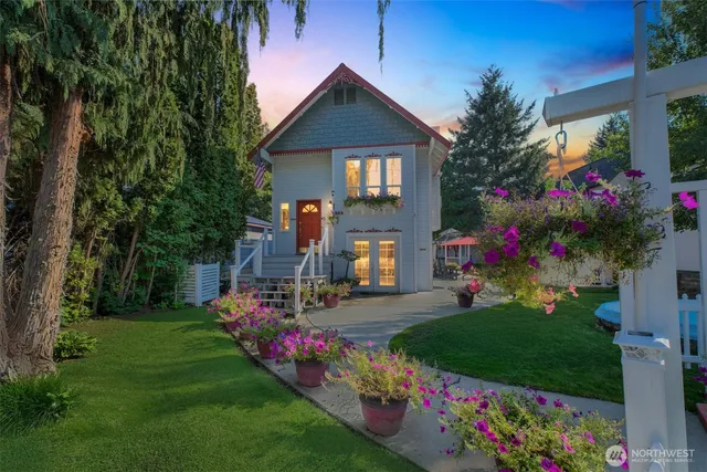 a front view of a house with a big yard and potted plants