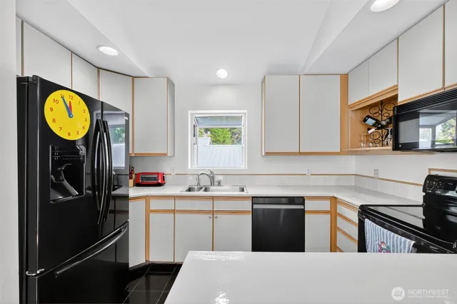 a kitchen with a sink a stove cabinets and a refrigerator