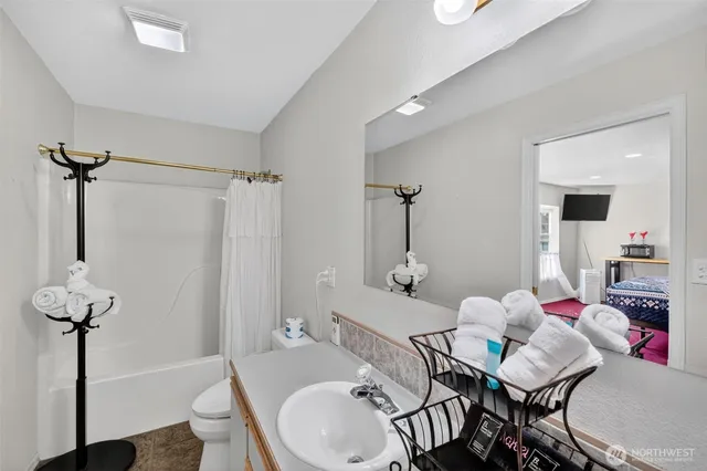a bathroom with a sink mirror toilet and shower