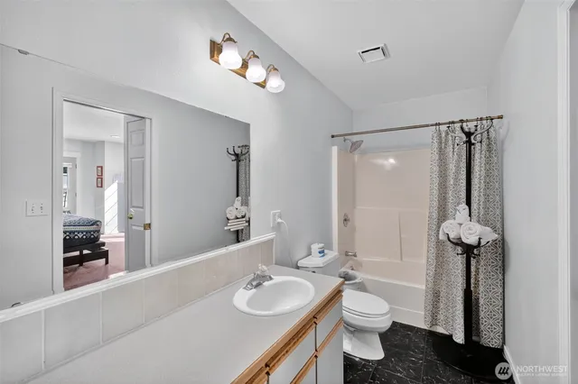 a bathroom with a granite countertop sink toilet and shower