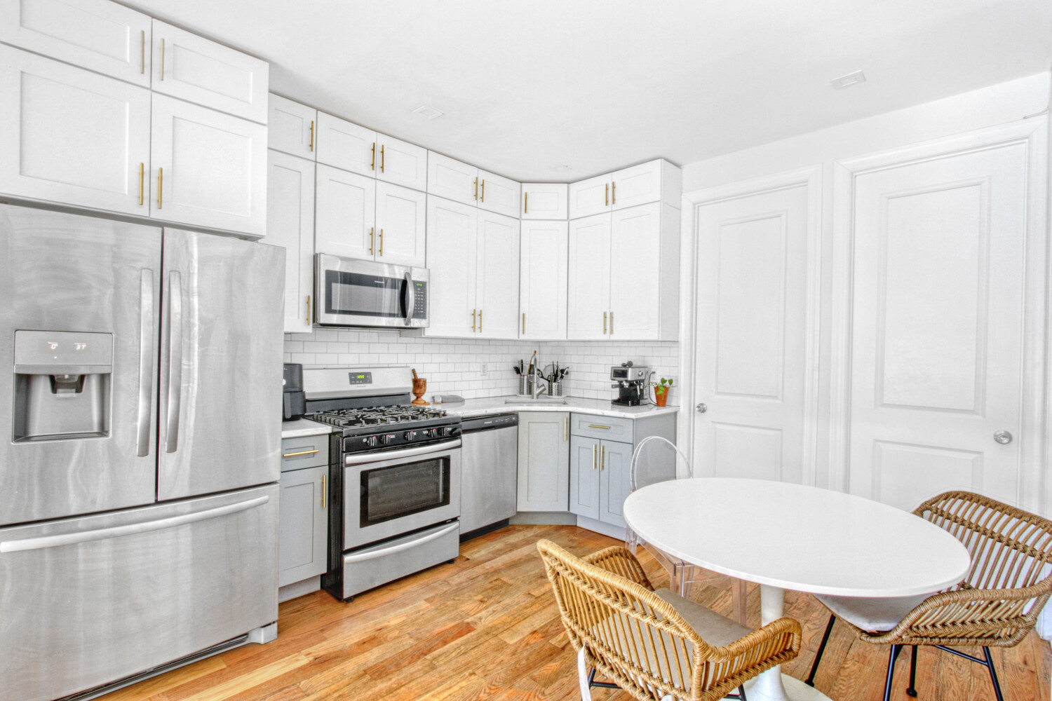 1353 Saint Marks Avenue, Unit 1 Brooklyn, NY 11233 - Photo 5 of 17 a kitchen with stainless steel appliances a stove a sink refrigerator and white cabinets with wooden floors