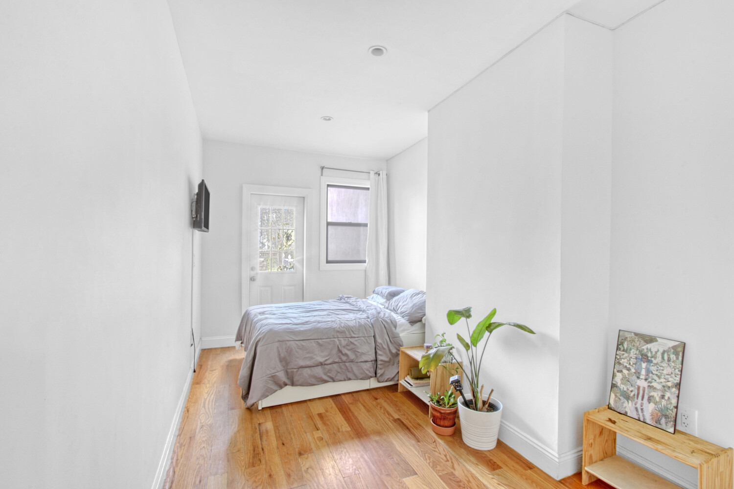 1353 Saint Marks Avenue, Unit 1 Brooklyn, NY 11233 - Photo 6 of 17 a bedroom with a bed and a wooden floor