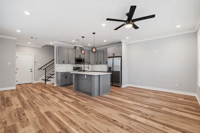 a kitchen with stainless steel appliances kitchen island a refrigerator sink and cabinets