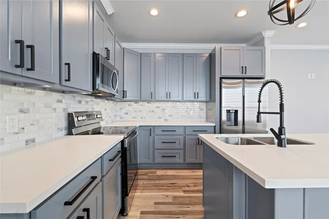 a kitchen with kitchen island granite countertop a sink stainless steel appliances and cabinets