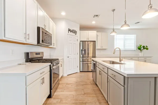 a kitchen with stainless steel appliances granite countertop a sink and a refrigerator