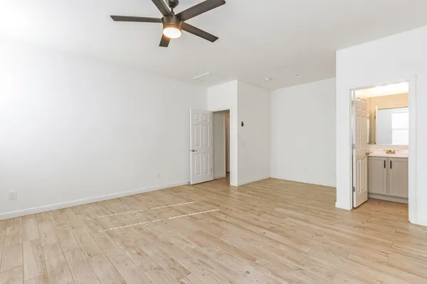 a view of a room with wooden floor and a ceiling fan