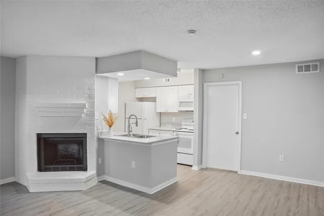 a kitchen with kitchen island a sink cabinets and stainless steel appliances