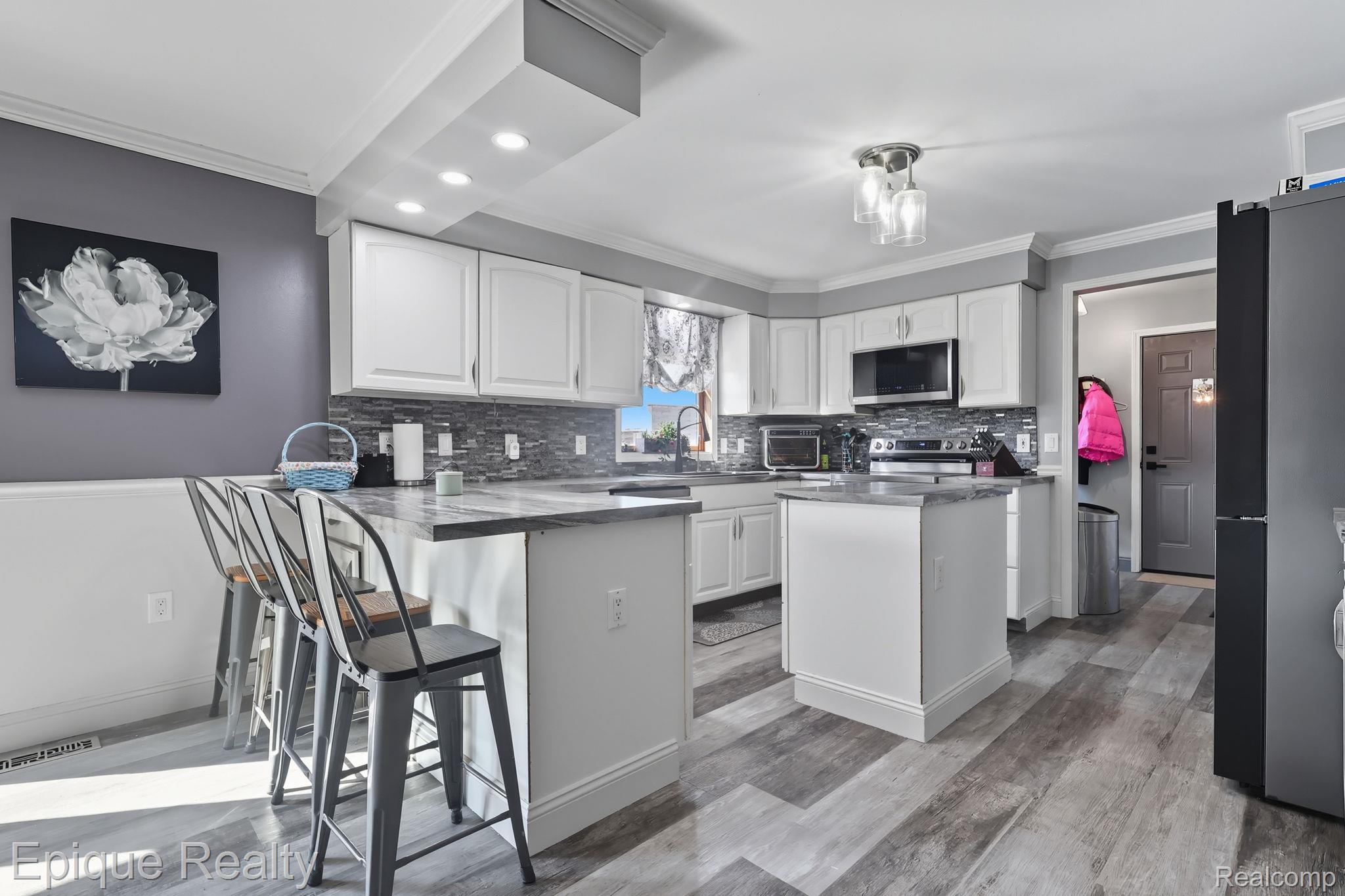 13265 Tibbets Road Memphis, MI 48041 - Photo 2 of 48 Kitchen with ornamental molding, white cabinetry, stainless steel appliances, backsplash, and a kitchen island