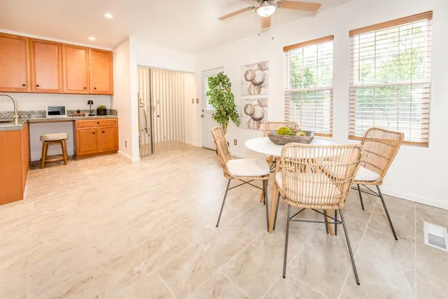 a large kitchen with stainless steel appliances granite countertop a stove top oven a sink a dining table and chairs