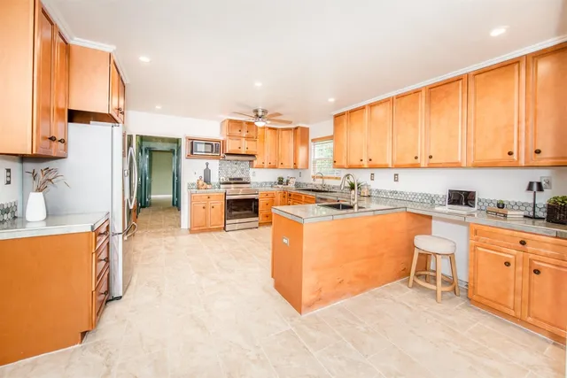 a large kitchen with stainless steel appliances granite countertop a stove a sink dishwasher and a refrigerator