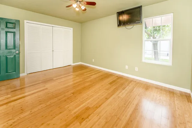a view of a room with wooden floor and a window