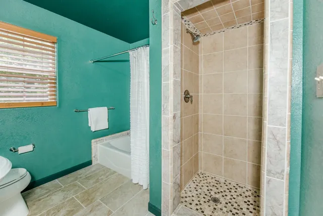 a spacious bedroom with a large bed a chandelier and closet