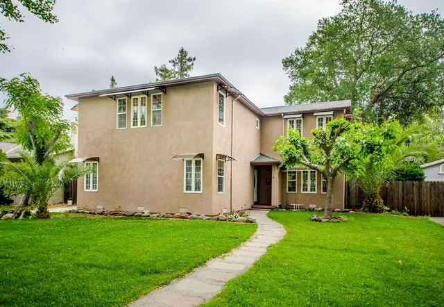 a front view of a house with a yard and outdoor seating