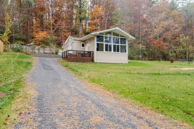 a white house with a big yard and large trees