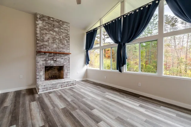 a view of an empty room with a fireplace and a window