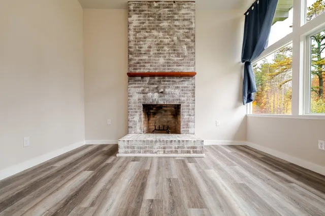 a view of an empty room with a fireplace and a window