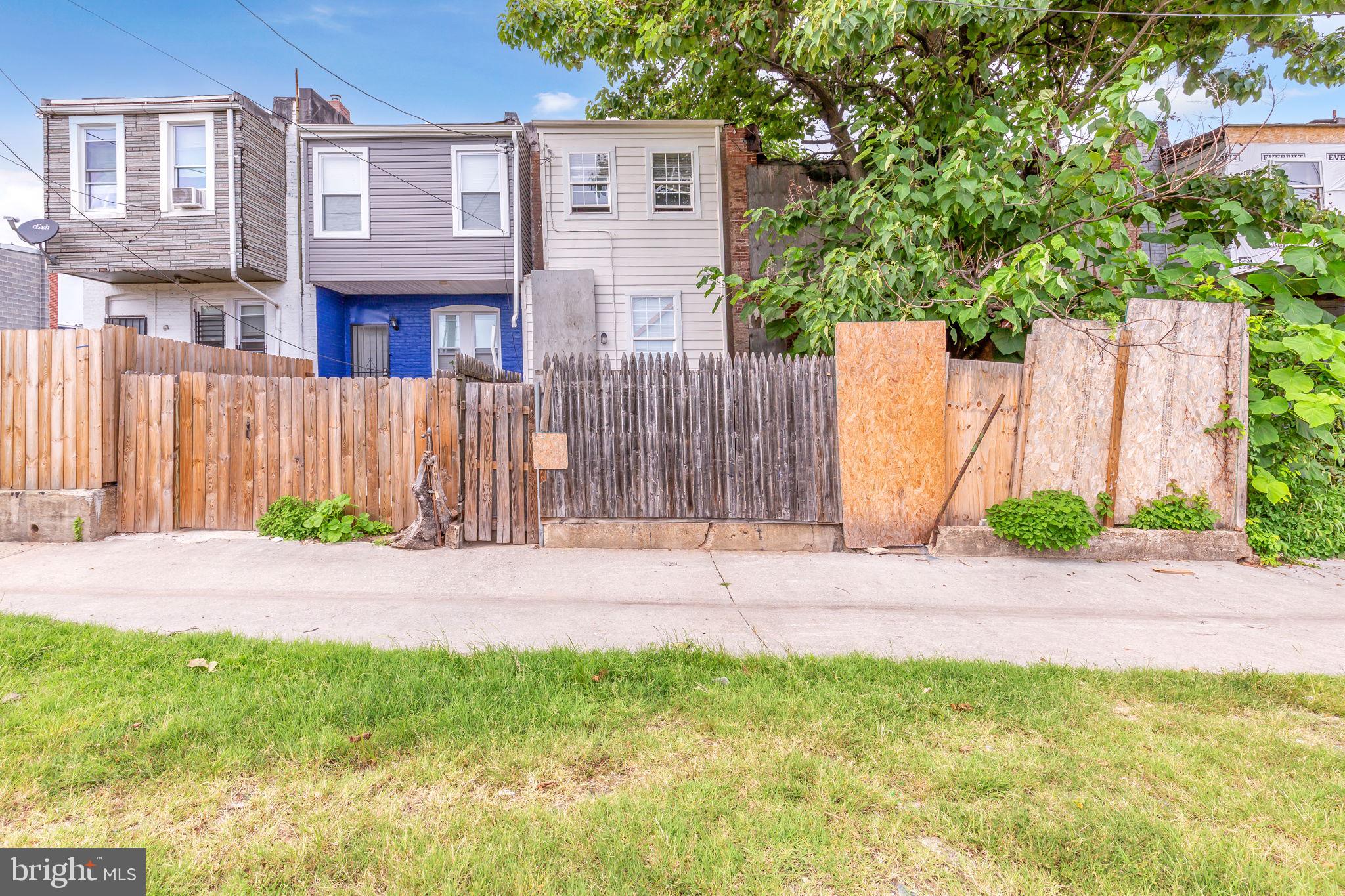 2315 East Madison Street Baltimore, MD 21205 - Photo 16 of 18 a view of a brick house with a yard and large trees