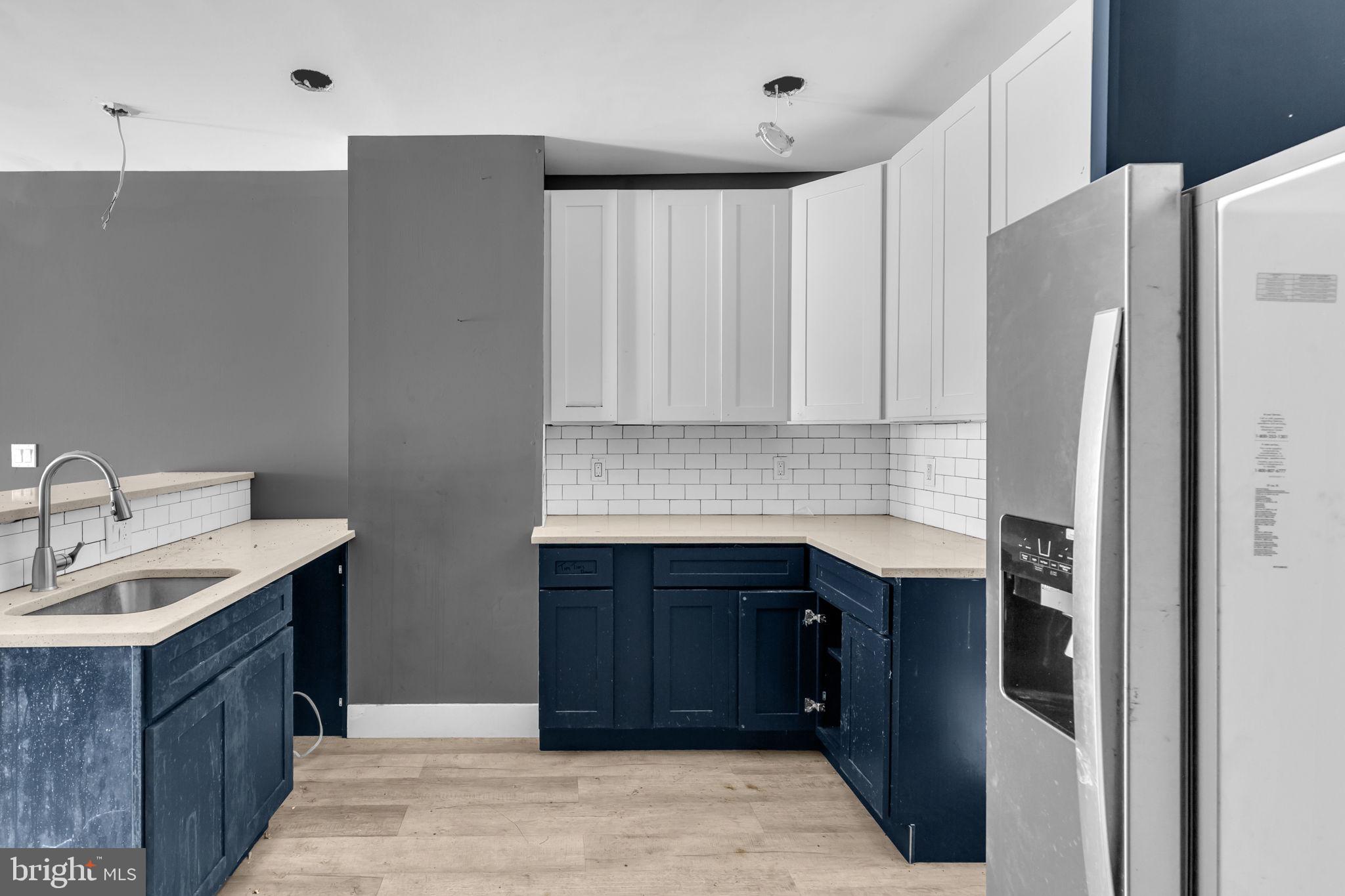 2315 East Madison Street Baltimore, MD 21205 - Photo 8 of 18 a kitchen with stainless steel appliances granite countertop a refrigerator and a sink