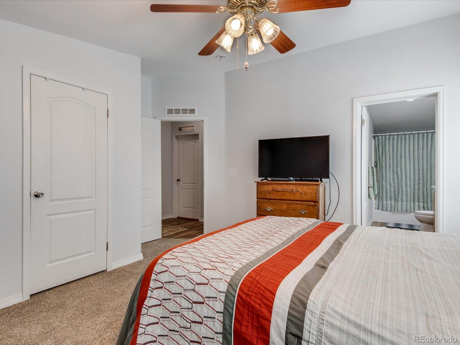 7775 Sage Green Frederick, CO 80530 - Photo 11 of 40 a bedroom with a bed and a flat screen tv