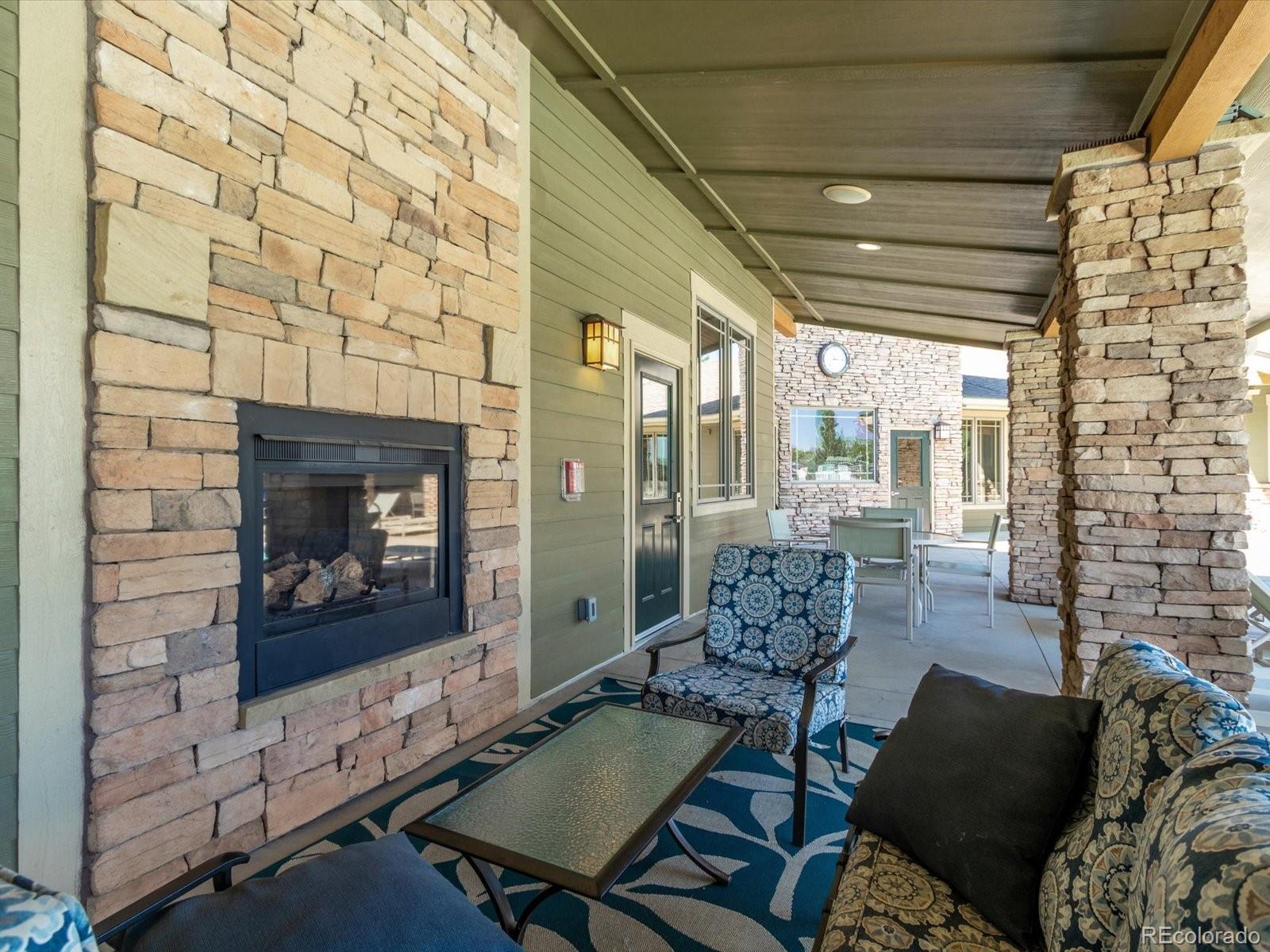 7775 Sage Green Frederick, CO 80530 - Photo 37 of 40 a living room with furniture a fireplace and a flat screen tv