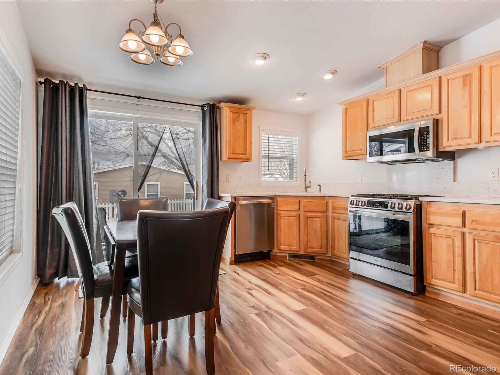 7775 Sage Green Frederick, CO 80530 - Photo 7 of 40 a kitchen with a table chairs and refrigerator