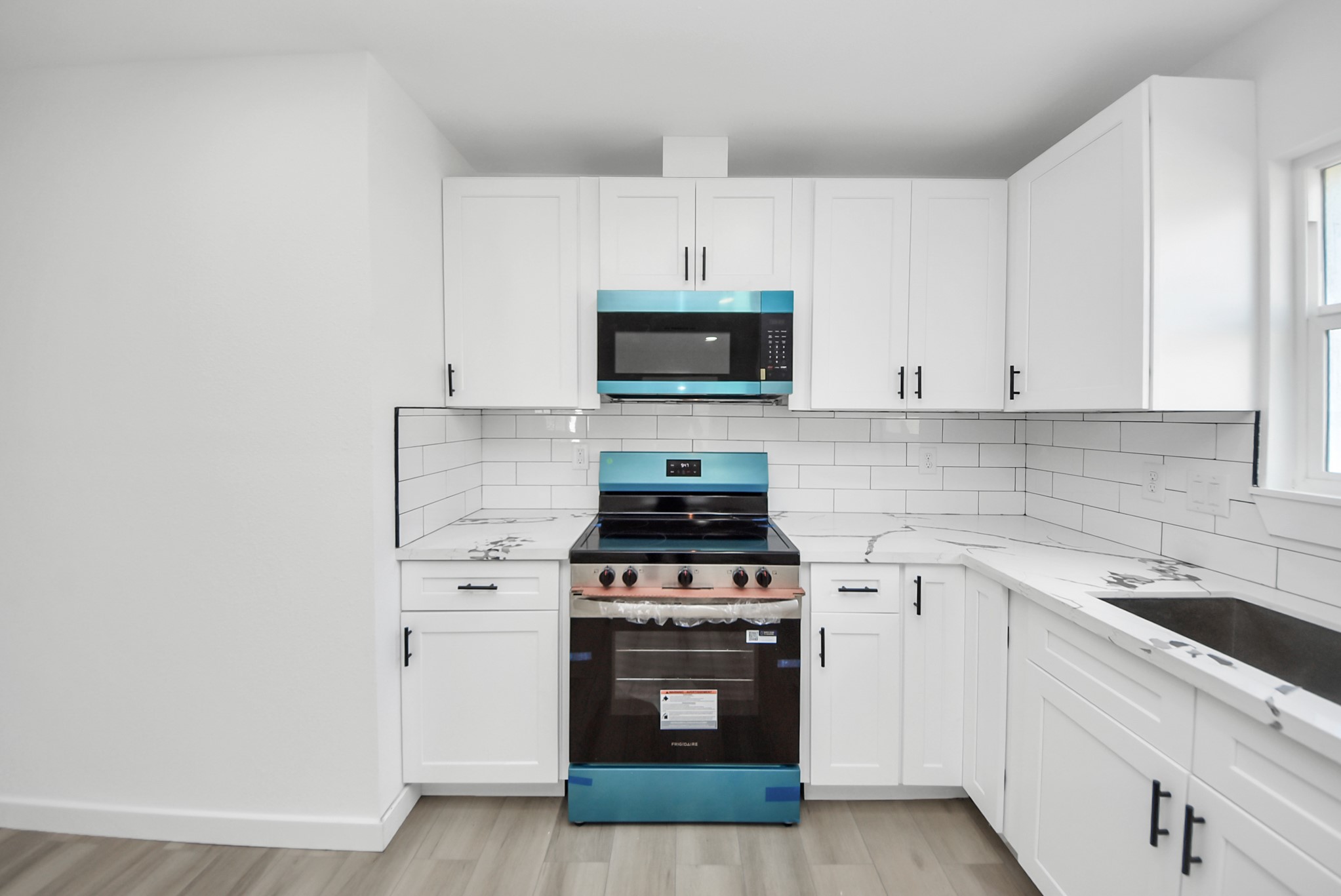 2701 Mustang Road Alvin, TX 77511 - Photo 14 of 45 a kitchen with stainless steel appliances a stove a microwave and cabinets