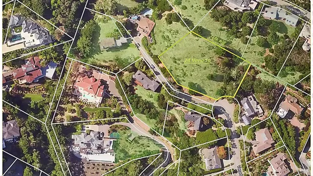 an aerial view of residential houses with outdoor space and trees all around