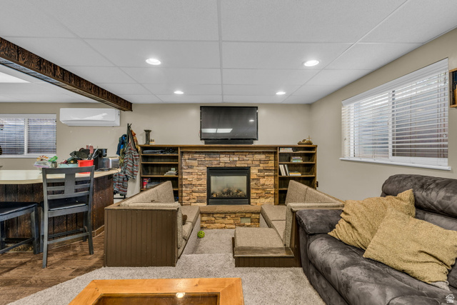 10705 Green Ridge Drive Sandy, UT 84070 - Photo 31 of 55 Living area featuring a stone fireplace, healthy amount of natural light, a drop ceiling, and recessed lighting