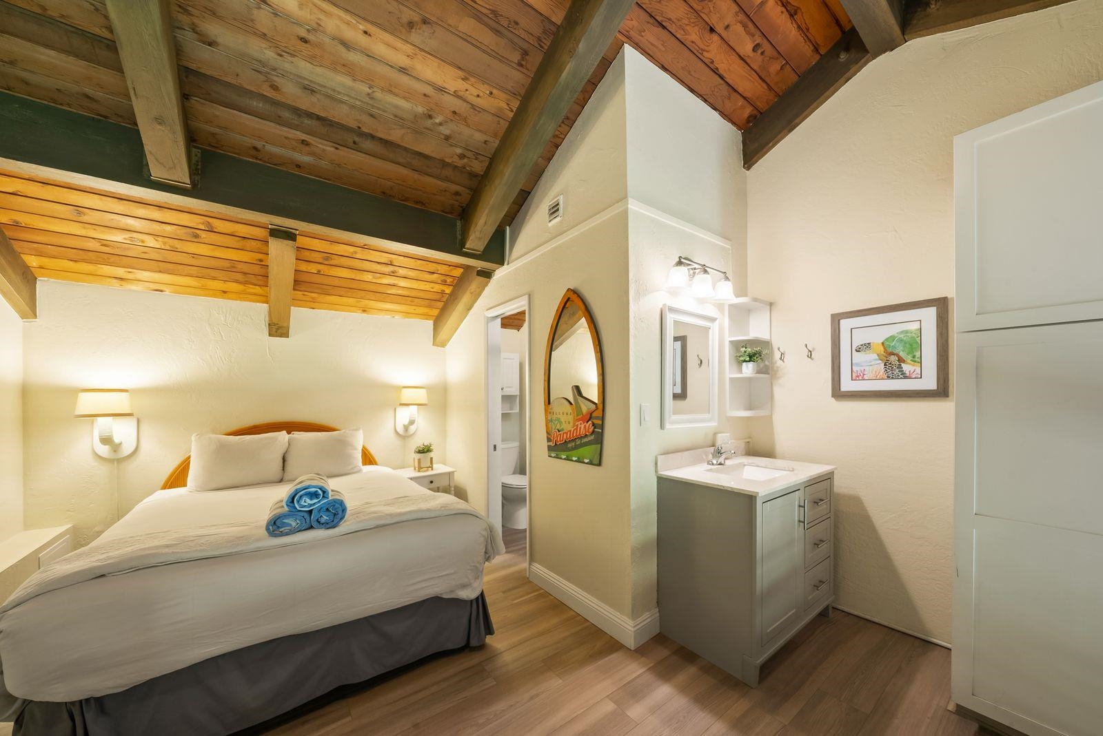 3543 Lower Honoapiilani Road, Unit J401 Lahaina, HI 96761 - Photo 13 of 25 a bedroom with a bed and wooden floor