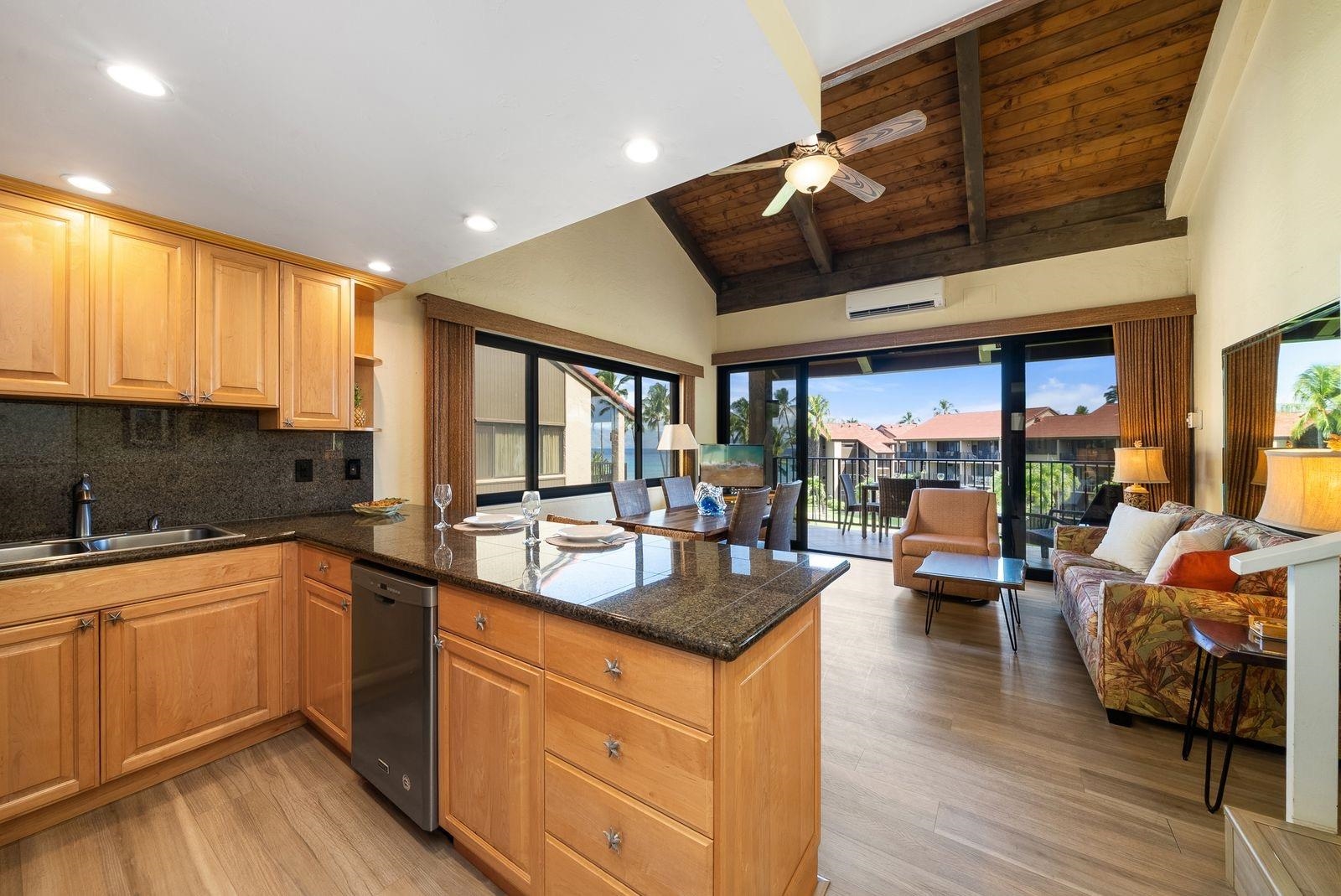3543 Lower Honoapiilani Road, Unit J401 Lahaina, HI 96761 - Photo 8 of 25 a kitchen with stainless steel appliances granite countertop a sink stove and wooden cabinets