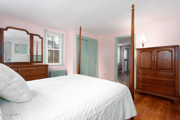 a bedroom with a large bed and a dresser