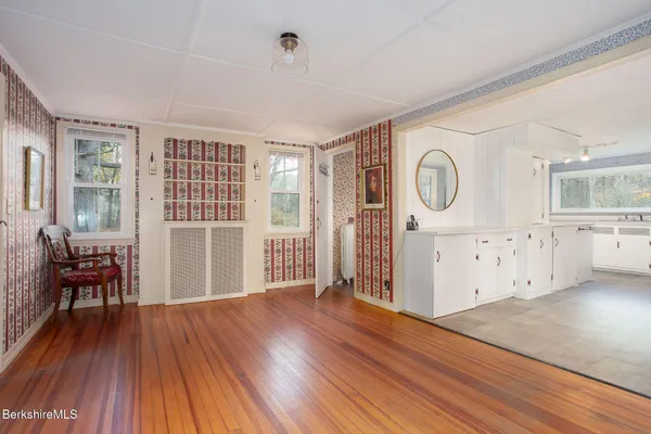 a view of a livingroom with wooden floor and furniture