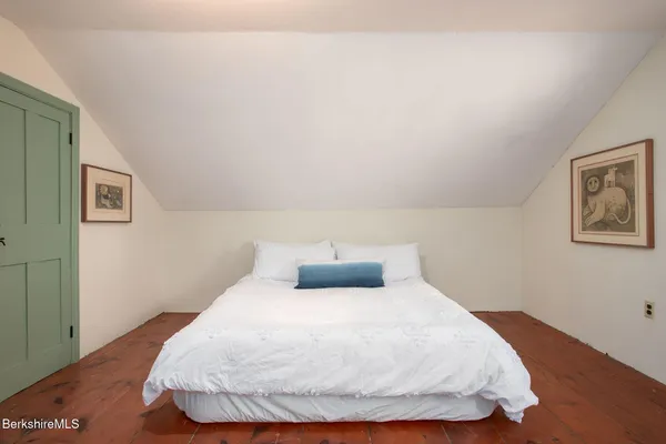 a bedroom with a bed and painting on the wall