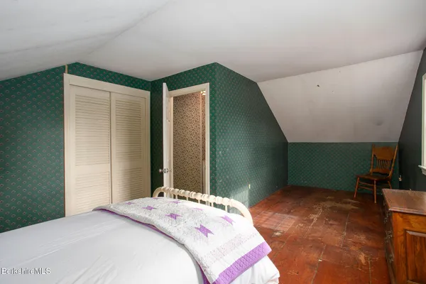 a bedroom with a bed and a mirror