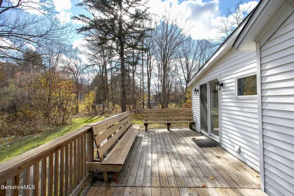 a view of a balcony with wooden floor and bench
