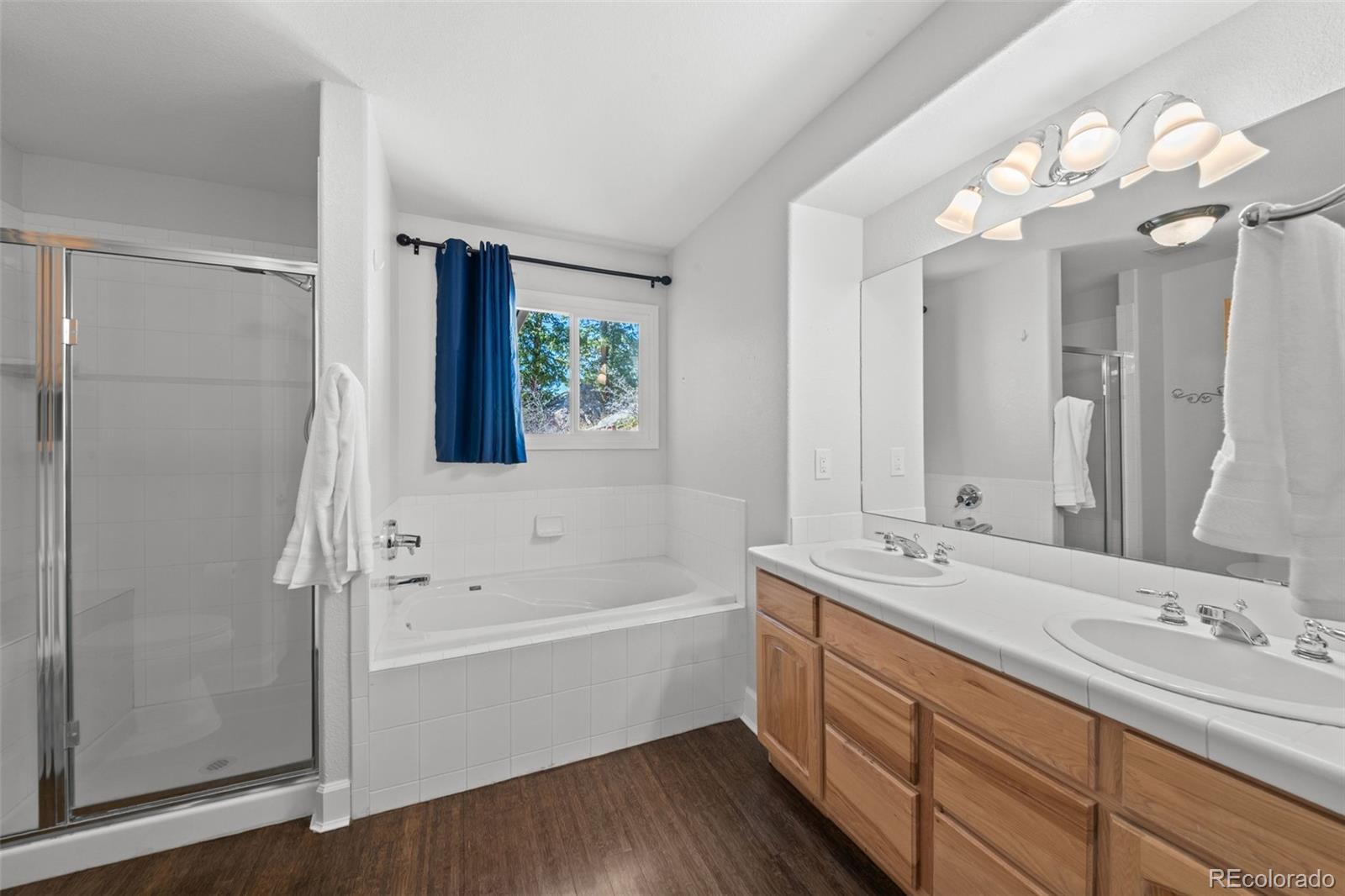 33633 Elk Run Evergreen, CO 80439 - Photo 27 of 39 a bathroom with a tub a sink and a large mirror