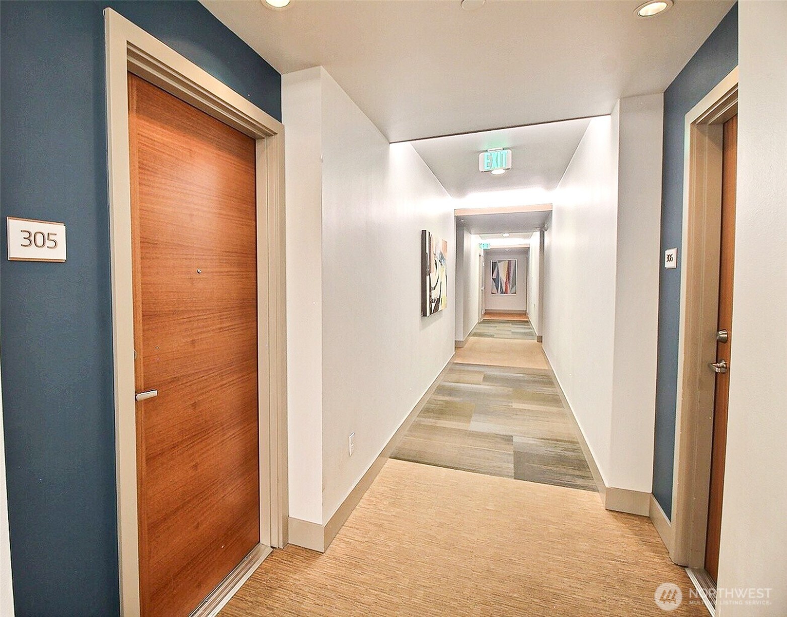 1760 Northwest 56th Street, Unit 305 Seattle, WA 98107 - Photo 12 of 24 a view of a hallway with wooden floor and a large mirror
