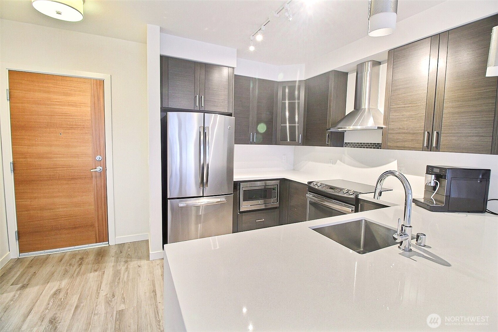 1760 Northwest 56th Street, Unit 305 Seattle, WA 98107 - Photo 3 of 24 a kitchen with granite countertop a refrigerator and a sink