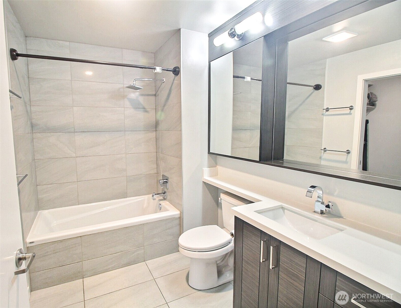1760 Northwest 56th Street, Unit 305 Seattle, WA 98107 - Photo 9 of 24 a bathroom with a bathtub shower sink vanity and toilet