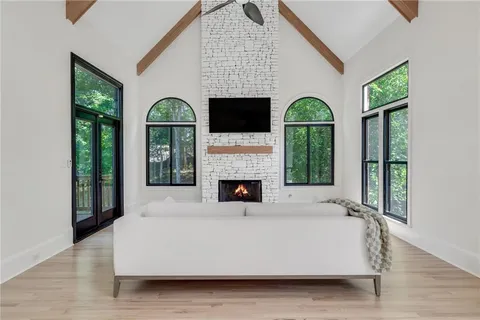 a living room with furniture a fireplace and a large window